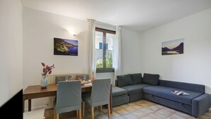 En moderne stue med spiseplads, sofa og to billeder på væggene.