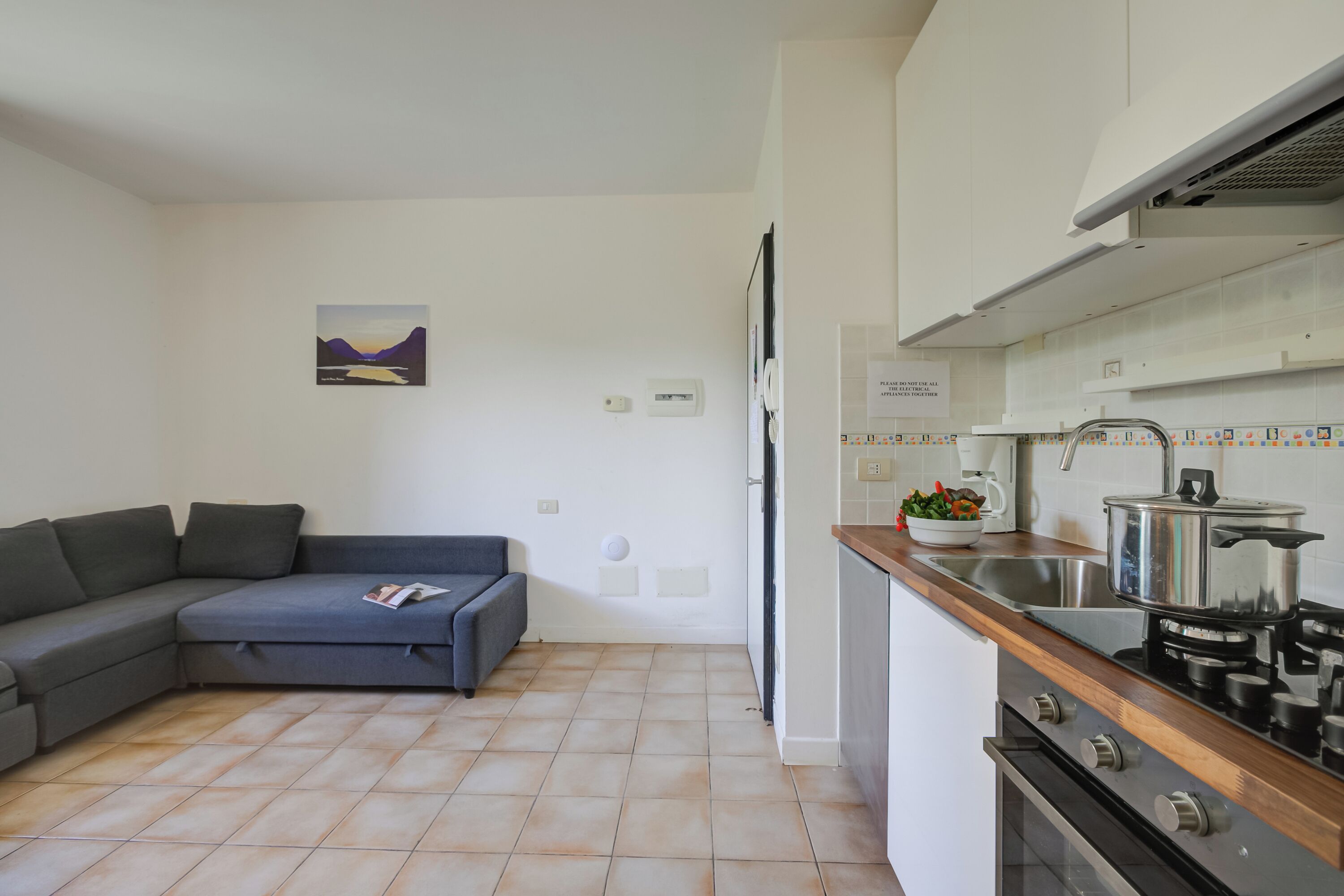 A modern kitchen with a stove, sink, and a dining area with a table and chairs.