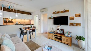 A modern living room with a sofa, a coffee table, a TV, and a wooden cabinet. - The Peace Of The Lake - Private Garden, Near Beach (Arco)