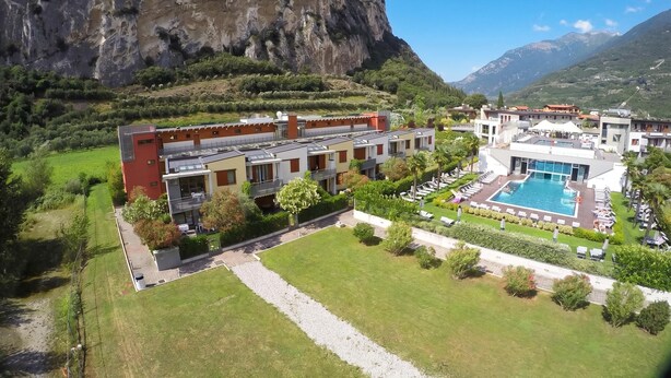 A hotel with a swimming pool, surrounded by greenery and a mountain backdrop. - The Peace Of The Lake - Private Garden, Near Beach (Arco)