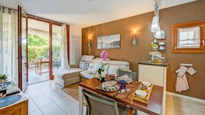 A modern living room with a sofa, dining table, and a view of the outdoors. - The Peace Of The Lake - Private Garden, Near Beach (Arco)
