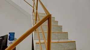 Un escalier avec des rampes en bois et des marches de couleur beige.