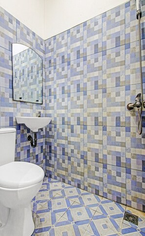 Habitación estándar doble | Baño | Ducha, cabezal de ducha tipo lluvia, toallas y papel higiénico