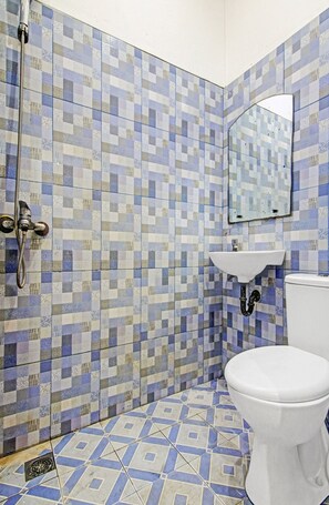 Un baño con paredes de baldosas de diseño cuadriculado, un lavamanos y un inodoro.