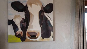 A painting of a cow on a wall. - A cottage that sleeps 8 guests  in 4 bedrooms (Castle Carrock)