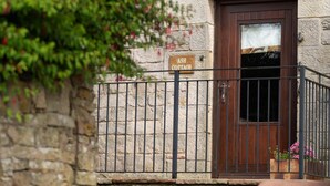 Un edificio de piedra con una puerta de madera y un letrero que dice 'ASH COTTAGE'.