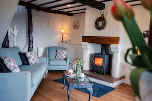 Relax in this inviting living room with a comfortable sofa, armchair, and traditional fireplace.