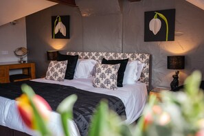 Cozy retreat with a patterned headboard, bedside table, and framed artworks.