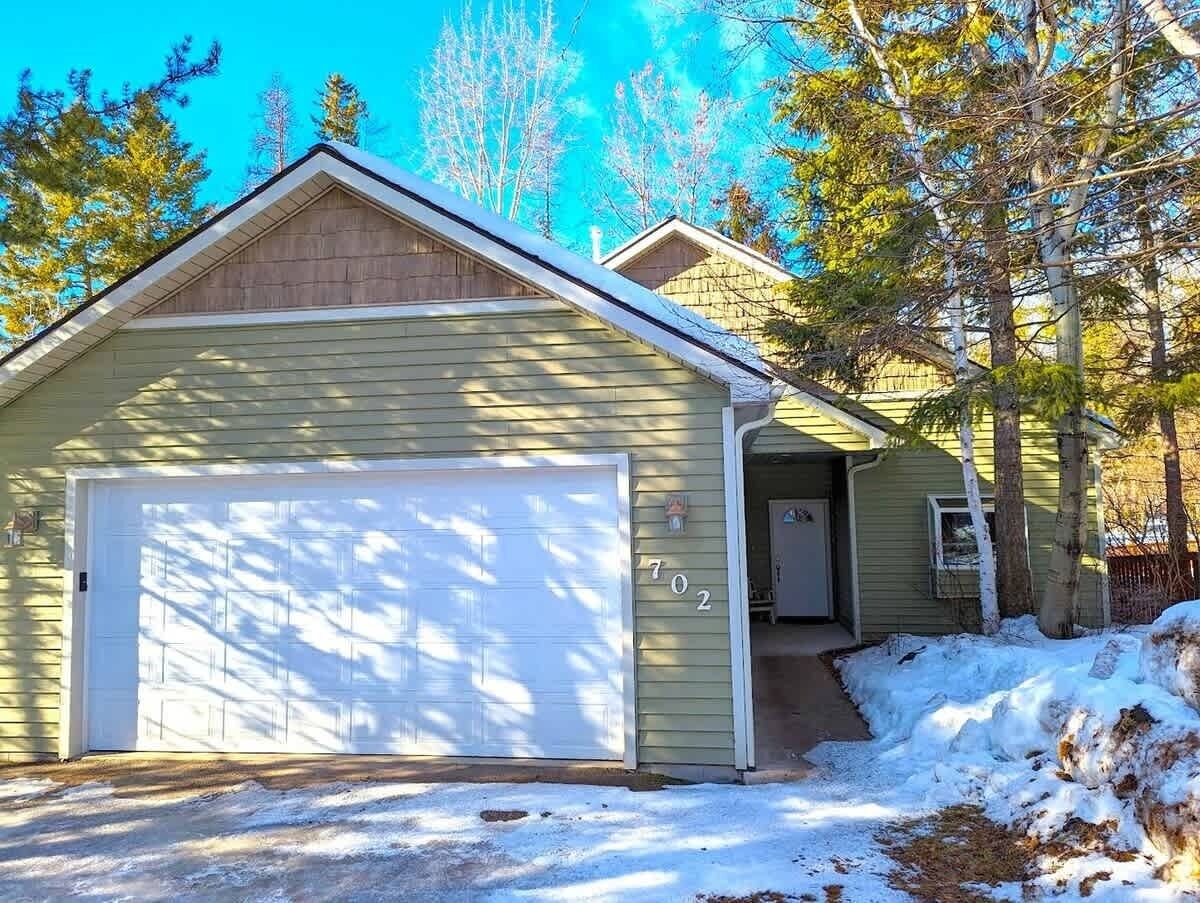 A single-story house with a garage, a covered porch, and a small attached shed.
