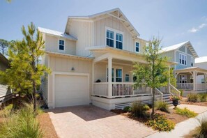 A two-story house with a covered porch and a garage. - 5 Minute Walk to Pool! 6-Seater Cart & 8 Bikes! Sleeps 15! - Just Beachy at NatureWalk on 30A (Santa Rosa Beach)