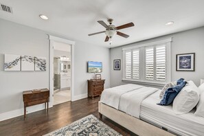 A bedroom with a bed, a ceiling fan, a TV, and artwork on the walls. - 5 Minute Walk to Pool! 6-Seater Cart & 8 Bikes! Sleeps 15! - Just Beachy at NatureWalk on 30A (Santa Rosa Beach)