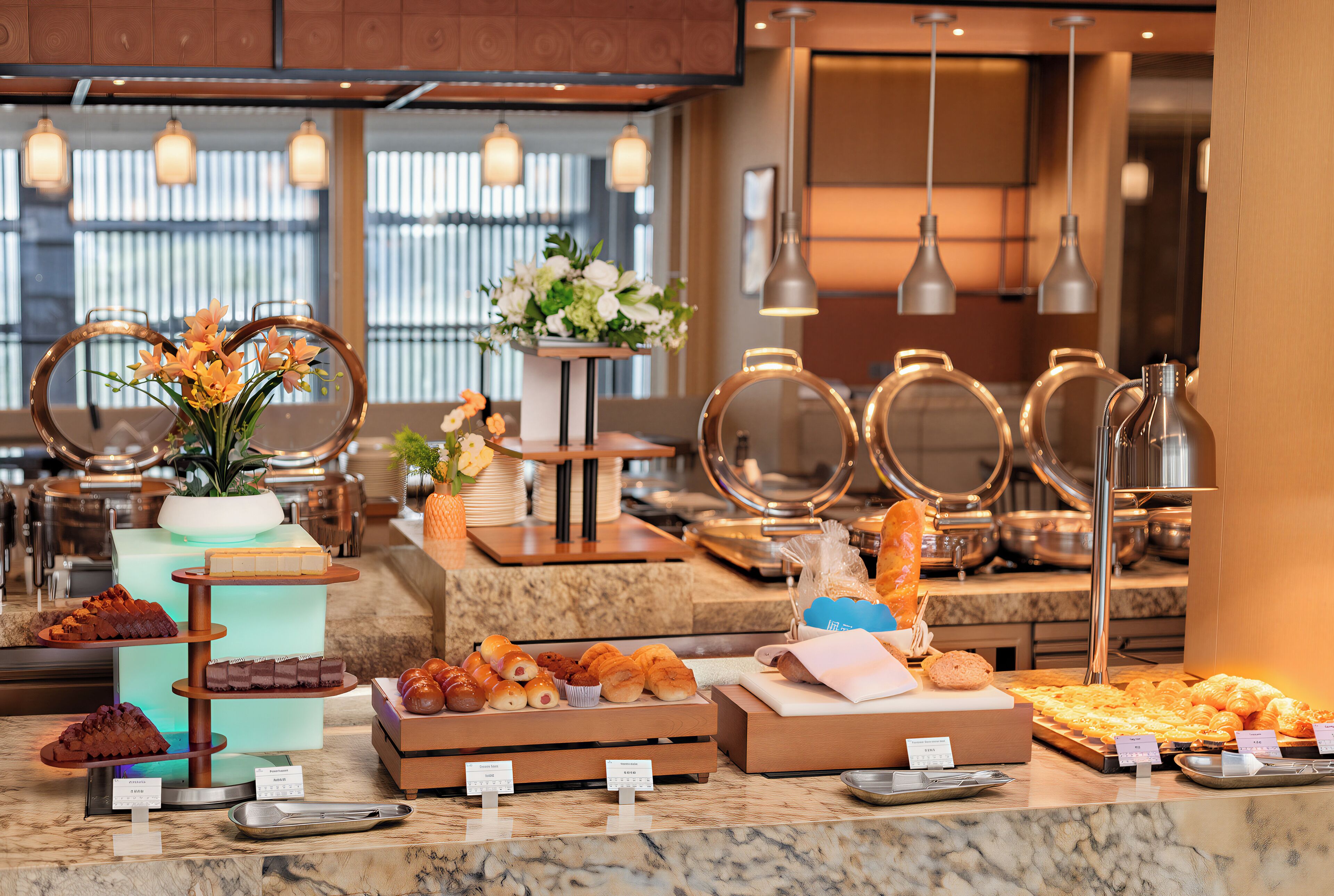 A buffet with various food items and a floral centerpiece.
