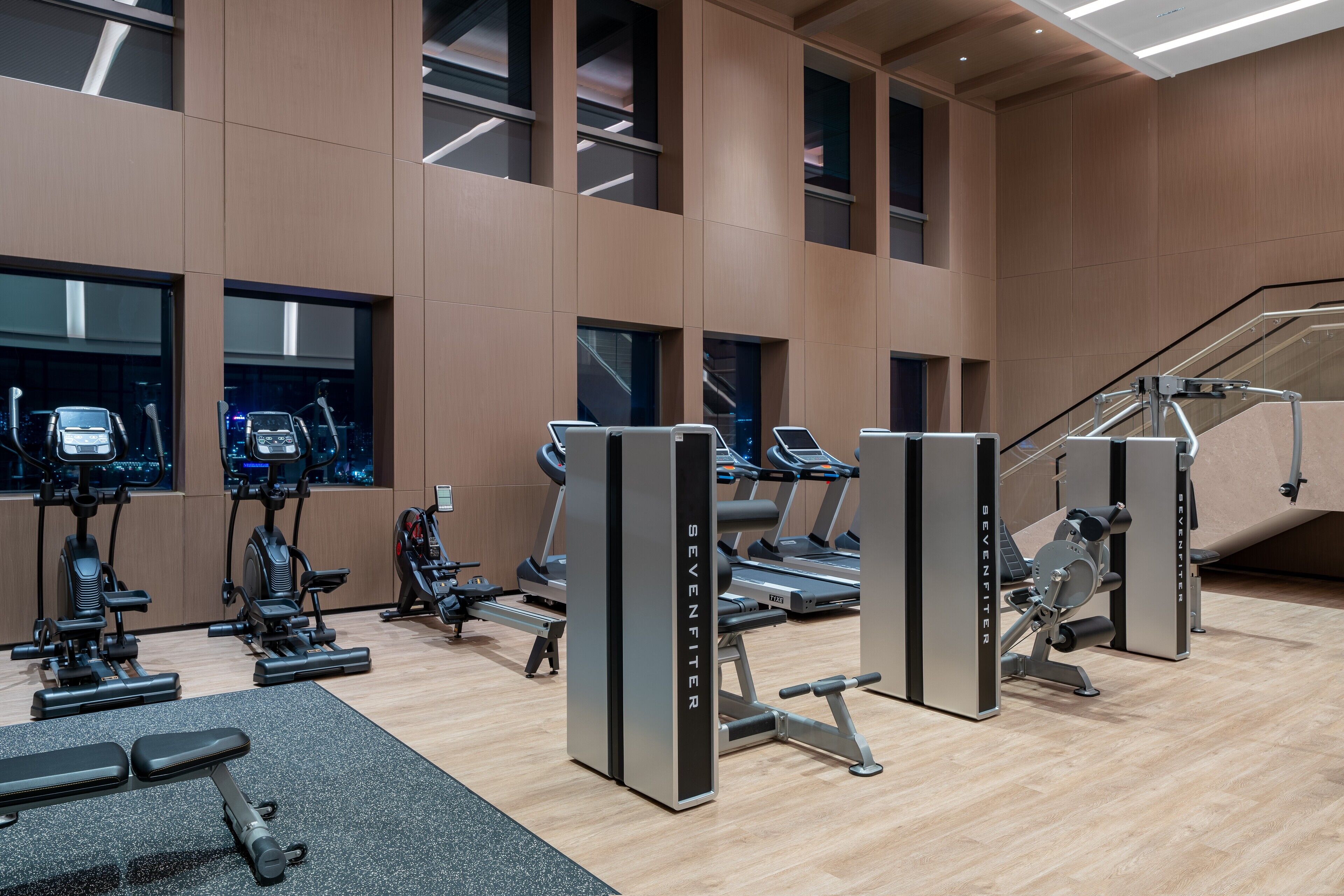 A gym with treadmills, elliptical machines, and weight equipment.