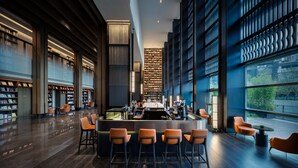 Eine moderne Bibliothek mit einer zentralen Insellösung, Bücherregalen und Sitzbereichen.