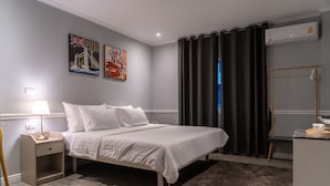 Une chambre à coucher bien rangée, avec un lit, une table de chevet, une lampe et une œuvre d’art accrochée au mur.