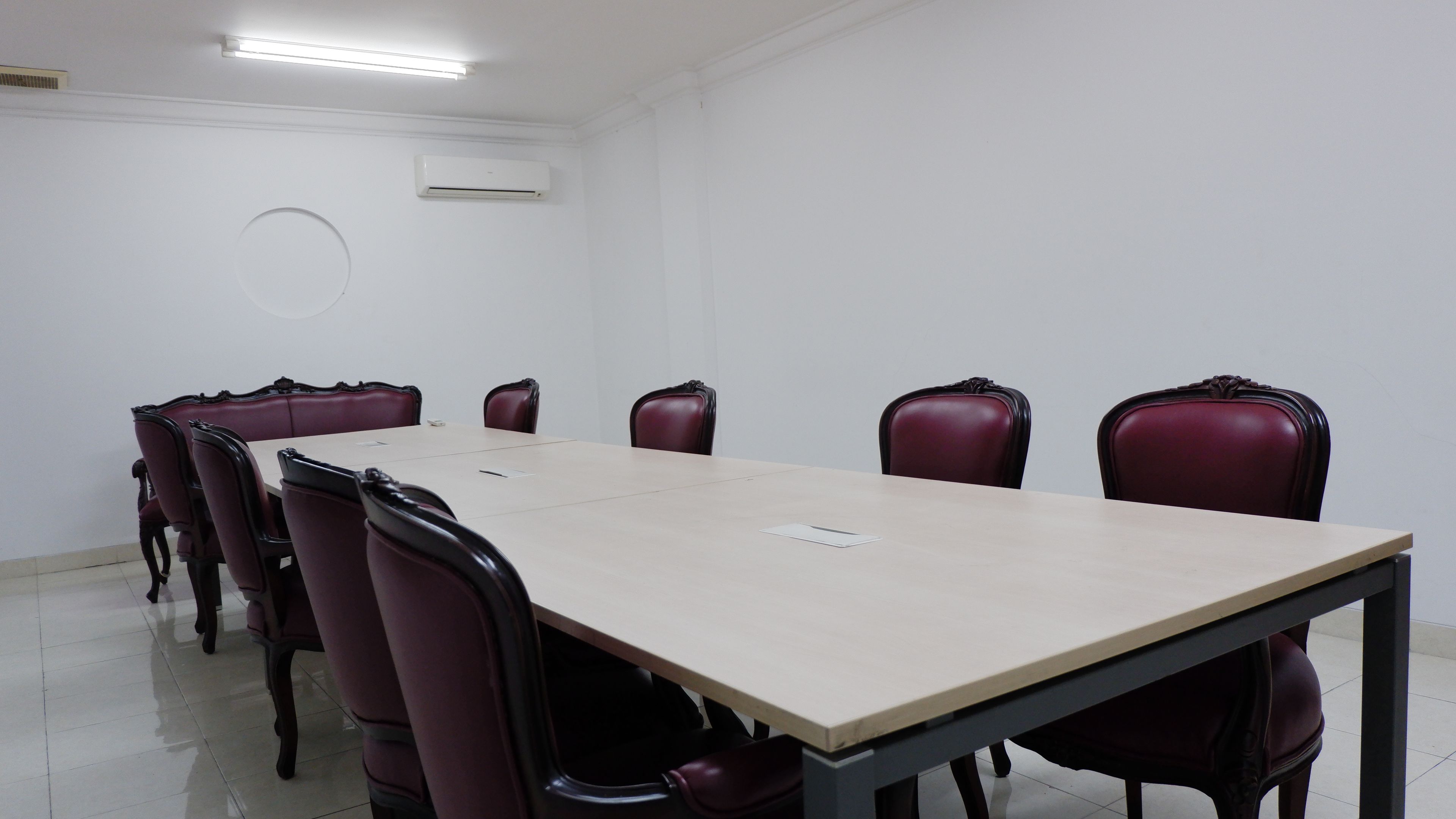 Une salle de conférence avec une table rectangulaire et six chaises.
