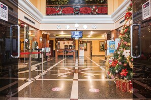 A lobby with a check-in counter, a Christmas tree, and a large screen. - Townhouse OAK Bi Executive (Jakarta)
