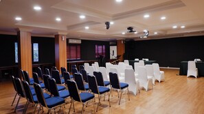 A conference room with rows of chairs, a stage with a podium, and a projector. - Palette Ancol Near Dufan Formerly BI Executive (Jakarta)