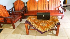 A room with a wooden sofa set, a matching wooden coffee table, and a laptop on the table. - Hotel O Desa Wisata Tunggul ArumNearWisata Tunggularum (Kaliurang)