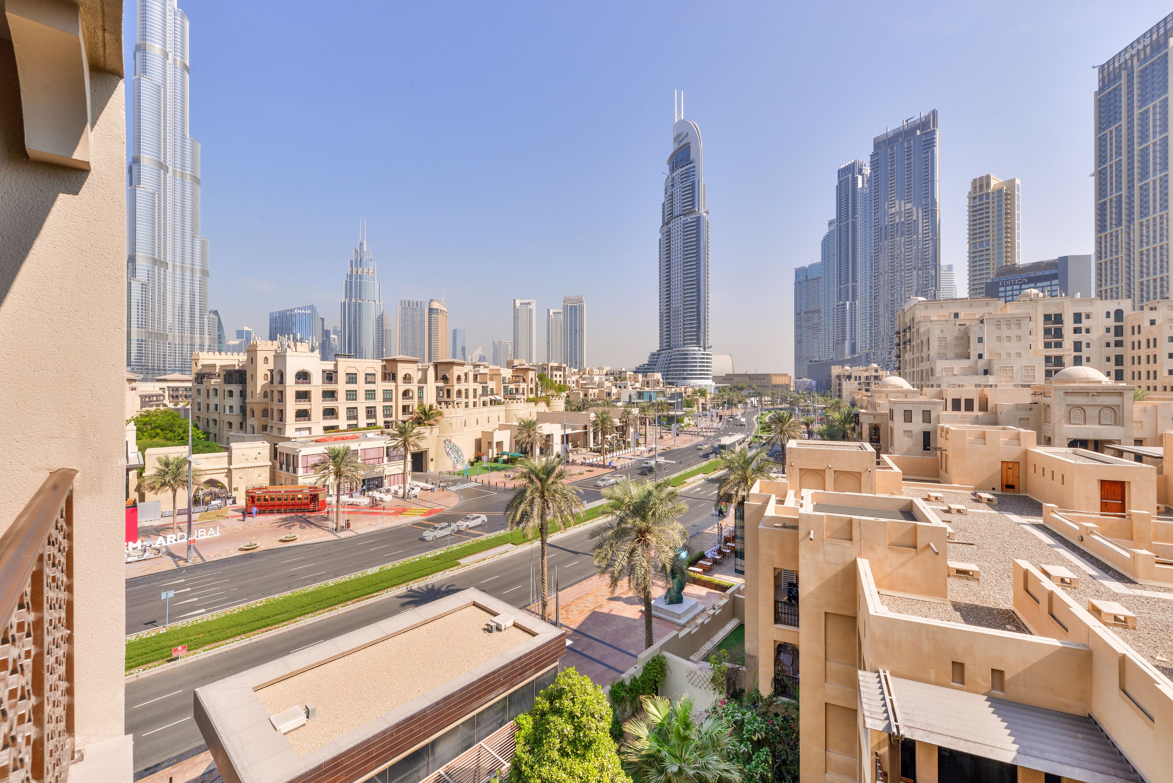 A cityscape with modern skyscrapers, a wide road, and traditional buildings.