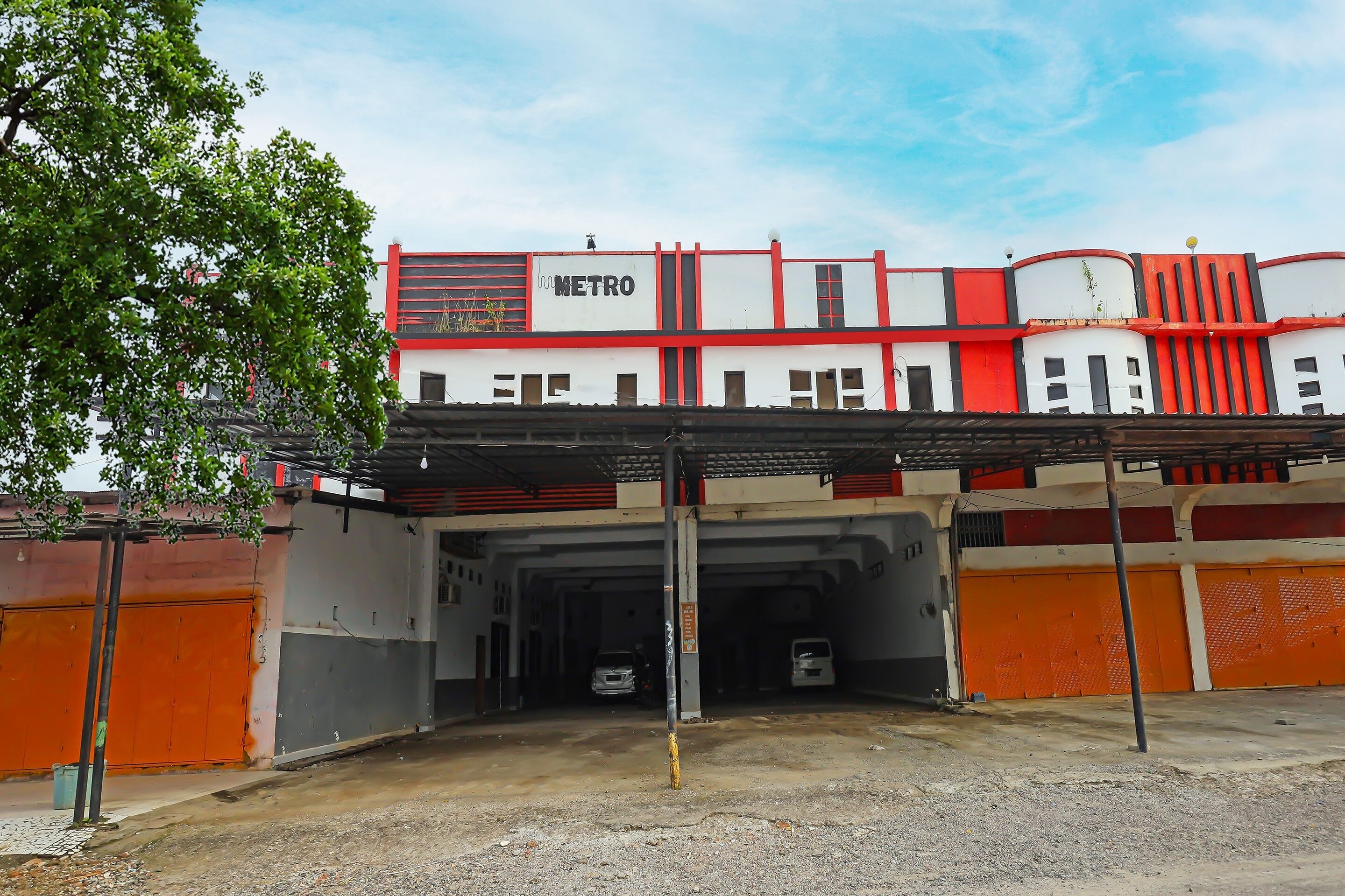 A building with a red and white facade, a sign reading "METRO", and multiple garage doors.