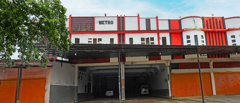 A building with a red and white facade, a sign reading "METRO", and multiple garage doors.