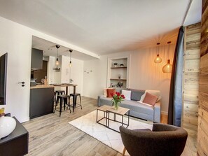 Een moderne woonkamer met een bank, salontafel en een eethoek met stoelen en een tafel.
