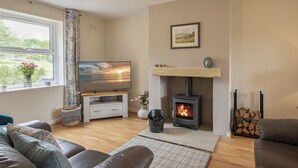 Una sala de estar acogedora con chimenea, televisor y asientos cómodos.