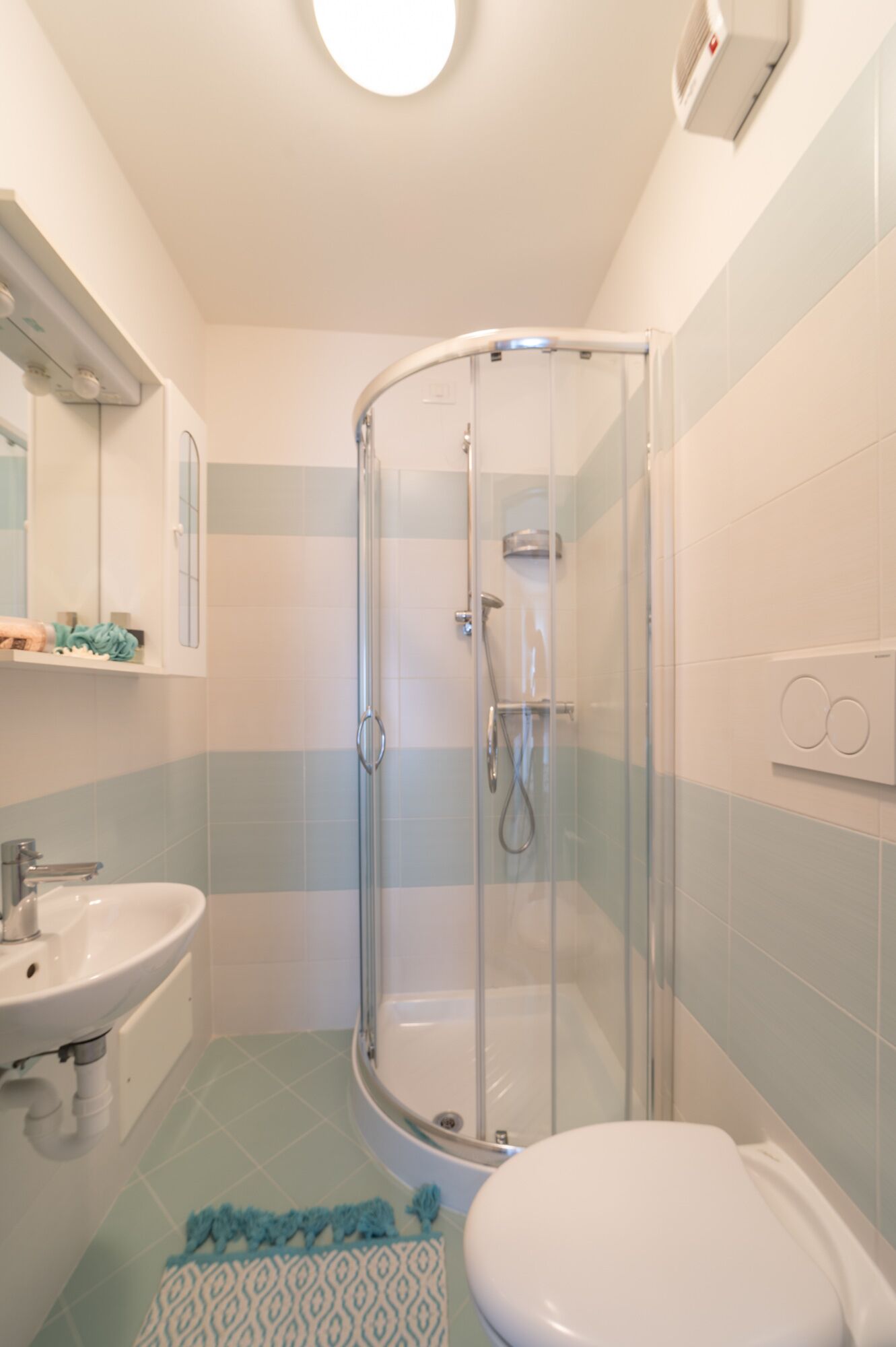 Ein modernes Badezimmer mit einer Duschkabine, einem Waschbecken und einer Toilette.