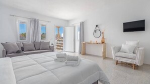Een moderne hotelkamer met een groot bed, een bank, een televisie en uitzicht.