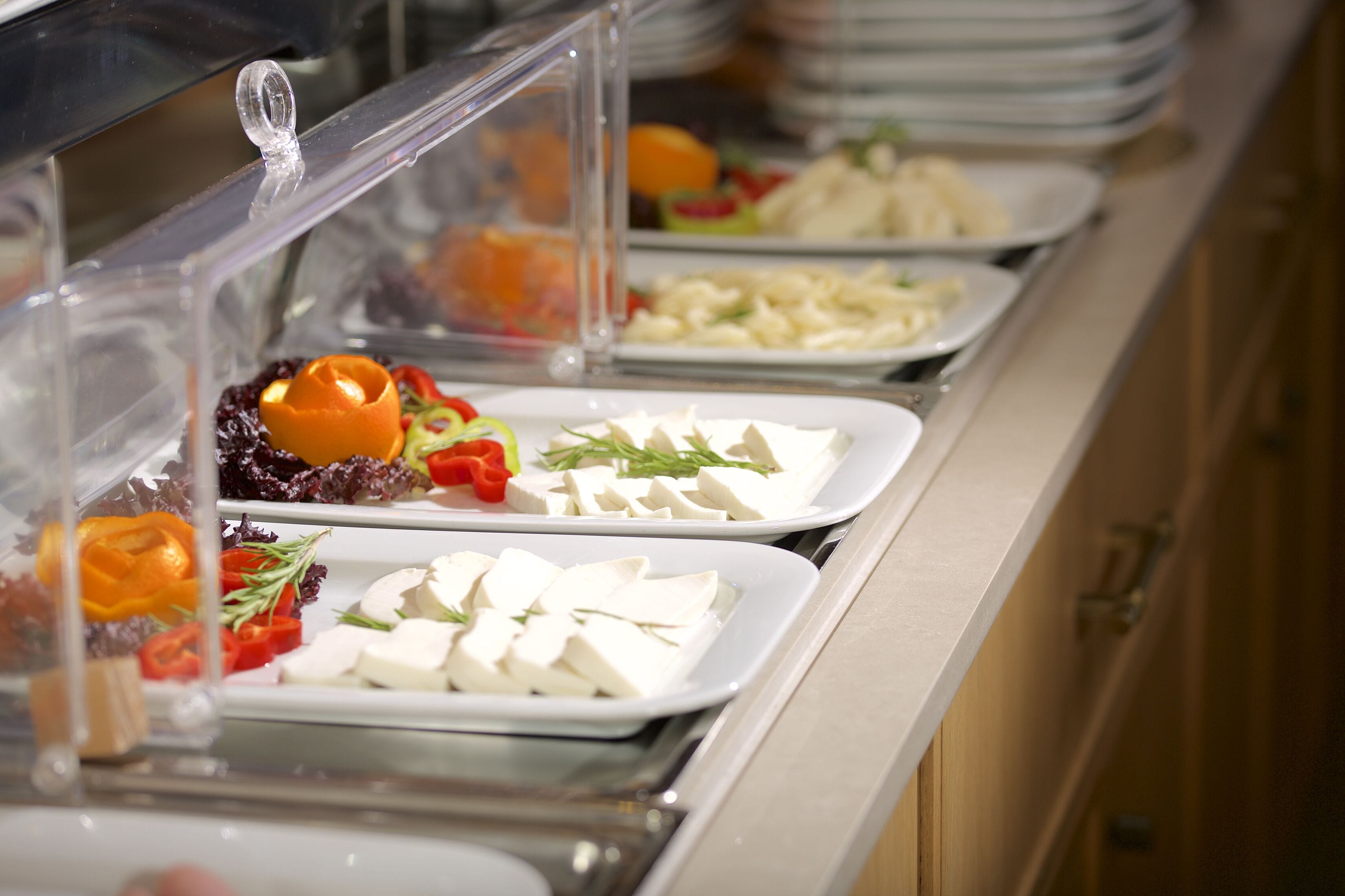 Un buffet proposant une variété de plats, notamment des salades, des fruits et des fromages.