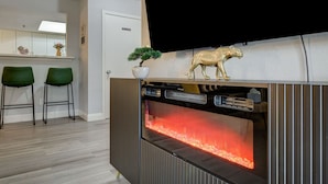 A modern kitchen with a built-in oven, two green bar stools, a potted plant, and a decorative leopard figurine on the counter. - Dreamy Vegas Strip area condo (Las Vegas)