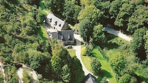 Vista aerea di una proprietà con una casa principale, un edificio più piccolo e una strada privata.