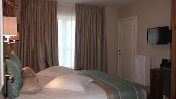 A hotel room with a bed, curtains, a television, and a sign that reads "SYDNEY".