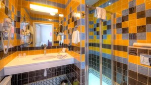 A bathroom with a white sink, a mirror, and a shower area with a glass door. - Hotel La Roseraie  (Wemmel)