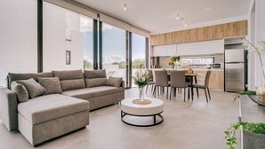 A modern living room with a sofa, coffee table, and dining area. - SunnyVillas:2BR+Ensuite CozyVilla*Private Pool*AL9 (Paralimni)
