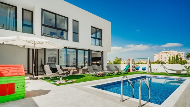 Ein modernes Gebäude mit Swimmingpool, Außenbereich und Blick auf andere Häuser.