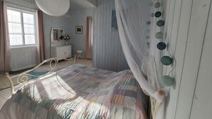 A bedroom with a bed, a vanity, a window, and a ceiling fan. - Charming Cottage in Taintrux: Hiking, Skiing, Close to Saint-Dié & Alsace Attractions (Taintrux)