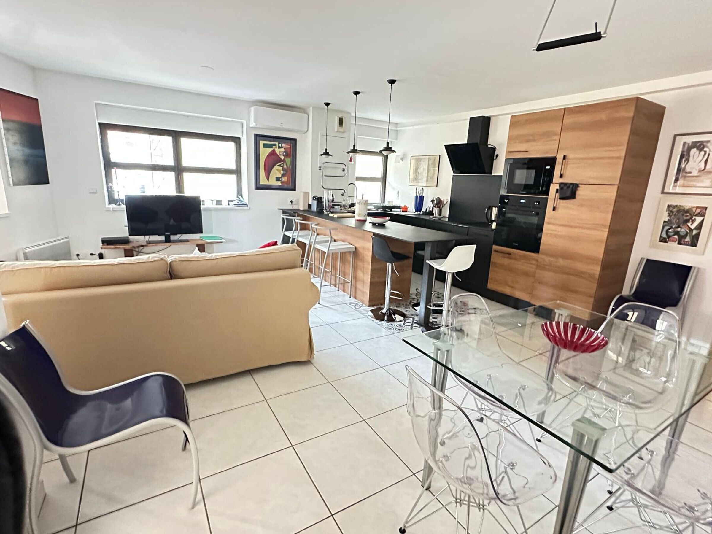 Een moderne keuken met een eethoek, een bank en een televisie.