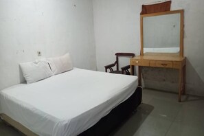 A simple bedroom with a single bed, a wooden dresser with a mirror, and a chair. - Super OYO 90483 Homestay Permata (Bangko)