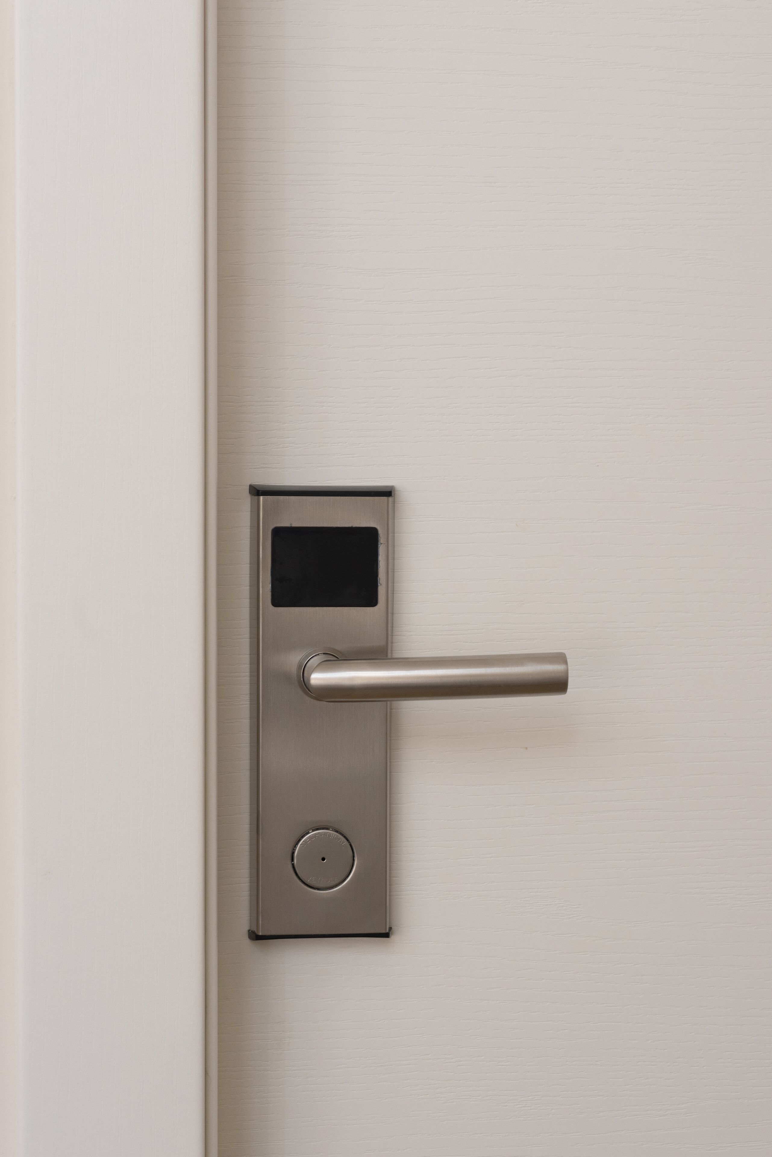 A modern door with a digital lock and a keyhole.