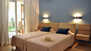 A double room with two beds, a balcony, and a view of the garden.