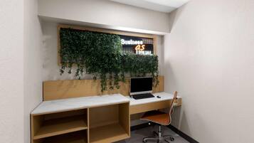 A modern office space with a wooden desk, a laptop, and a chair.