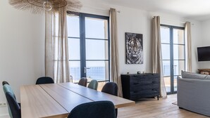A modern living room with a dining area, large windows, a flat-screen TV, and a grey sofa. - Villa NEPITA, swimming pool, sea view for 8 people, 4 bedrooms, ERBALUNGA, 20222 (Brando)