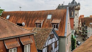 Una calle estrecha con casas tradicionales de entramado de madera, una iglesia con cúpula y una torre.