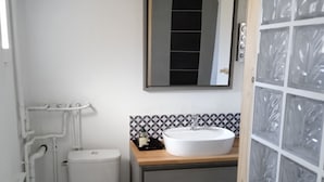 A compact bathroom with a toilet, sink, and mirror.