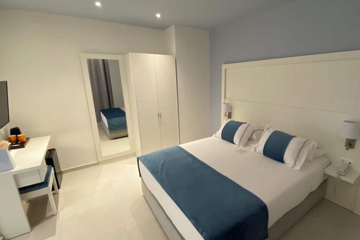 Quarto de hotel moderno com uma cama grande, uma escrivaninha e um guarda-roupa.