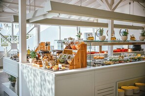 Un bufé de desayuno con diversas opciones de comida, frascos de vidrio y una estación de café.