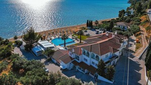 A coastal hotel with a swimming pool, beach access, and Mediterranean architecture. - Acrotel Lilyann Boutique Hotel (Sithonia)