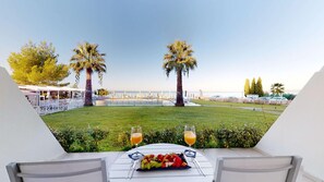 A terrace with a table set for two, a fruit platter, and two glasses of orange juice. - Acrotel Lilyann Boutique Hotel (Sithonia)